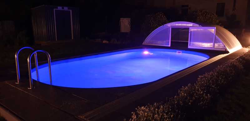 Pool mit lila Beleuchtung offen bei Nacht