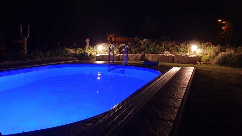 Pool mit lila Beleuchtung bei Nacht